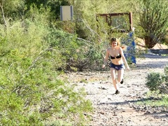 A blonde with nice boobs walks naked in the mountains